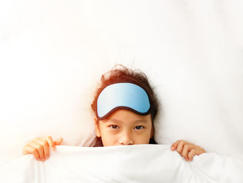 Portrait of cute girl lying on bed