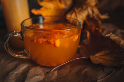Close up llarge mug of hot orange sea buckthorn tea in a cozy home autumn evening still life