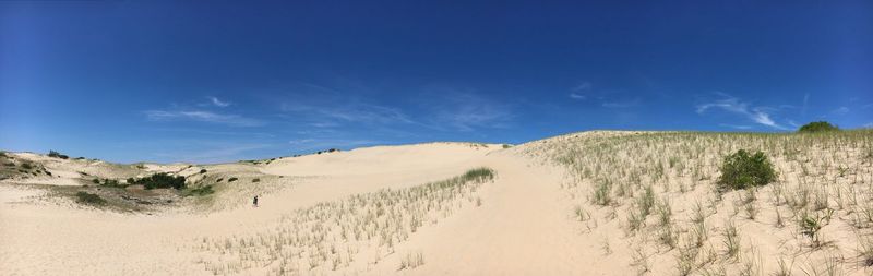 Panoramic view of desert against blue sky