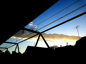 Low angle view of power lines against blue sky