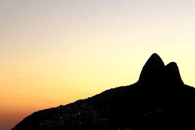 Silhouette mountain against clear sky during sunset