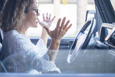 Side view of woman sitting in car