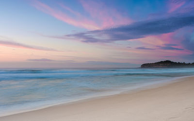 Scenic beach view of sea against sky during sunset