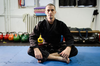 Portrait of young man sitting on floor