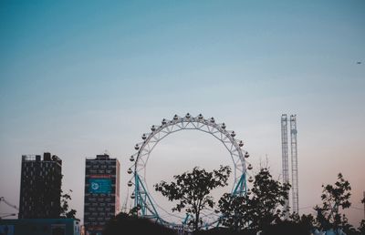 Low angle view of ferris wheel against buildings