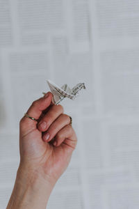 Close-up of hand holding paper crane