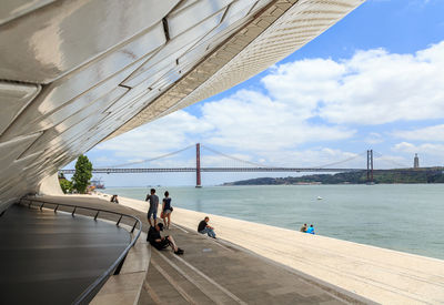 People on suspension bridge over sea