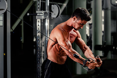 Shirtless man exercising in gym