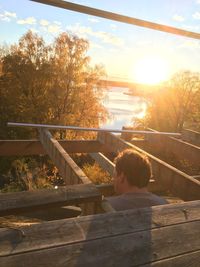 Rear view of man on railing against sky