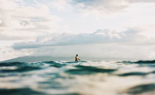 Man surfing in sea against sky