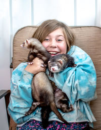 Young girl struggles to hold onto her pair of active ferrets