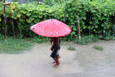 Man with umbrella standing outdoors during rainy season