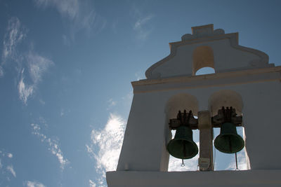 Low angle view of cross and building against sky