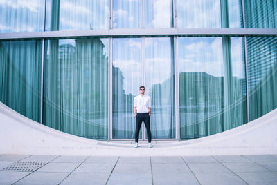 Full length of man standing by modern building