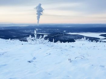 Smoke emitting from chimney against sky during winter