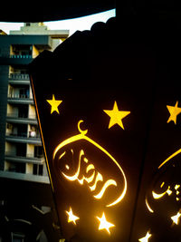 Low angle view of illuminated text on building at night