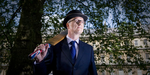 Portrait of young man standing against trees