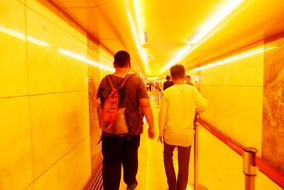 Rear view of people walking in subway station