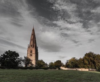 Tower amidst trees and buildings against sky