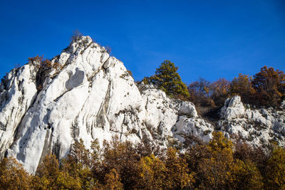 Low angle view of rocks against blue sky