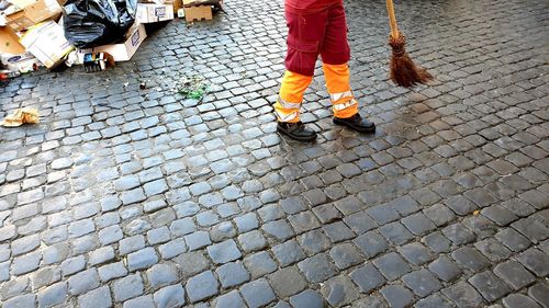 Low section of people walking on cobblestone street