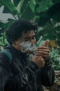 Portrait of teenage boy holding leaf