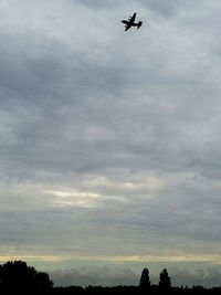 Low angle view of silhouette airplane against sky