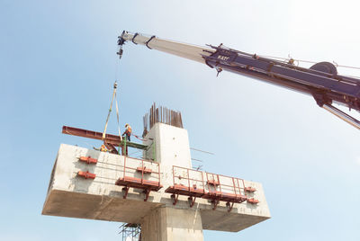 Low angle view of crane against clear sky