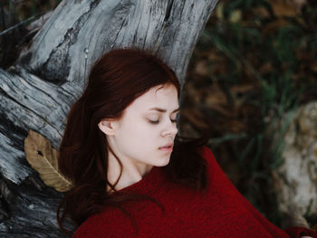 Portrait of woman with red tree trunk