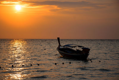 Silhouette boat in sea against sky during sunset