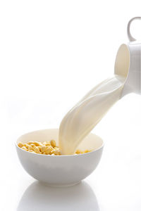 Close-up of milk pouring in bowl