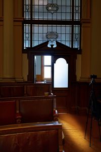 Illuminated electric lamp on table by window at home