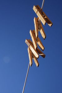 Low angle view of windmill against blue sky