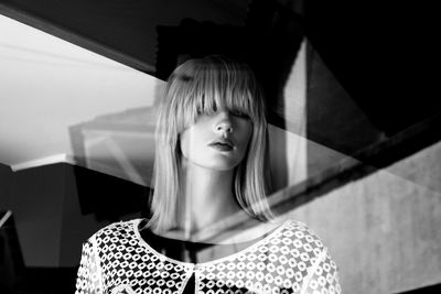 Portrait of beautiful young woman standing against wall