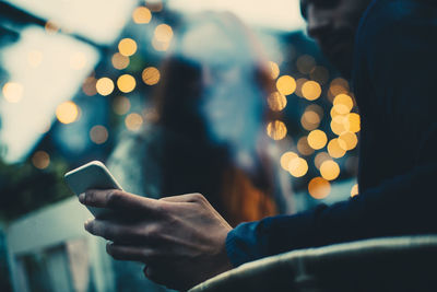 Midsection of man using mobile phone