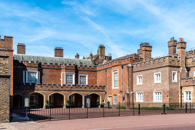 People walking by marlborough road in front of st james palace in westminster a sunny day