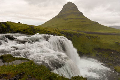 Scenic view of waterfall against mountain