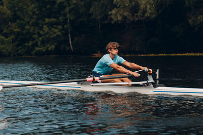 Man rowing canoe in lake