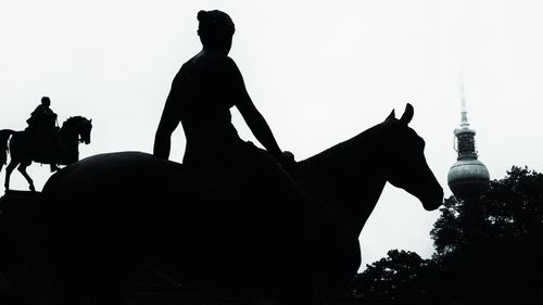 Low angle view of silhouette statue against sky