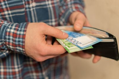 Midsection of man removing paper currencies from wallet