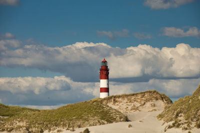 Lighthouse by sea against sky