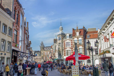 People on street in city against sky