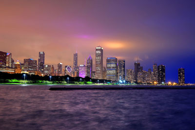 Illuminated buildings against sky at night