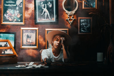 Portrait of woman sitting on table at home