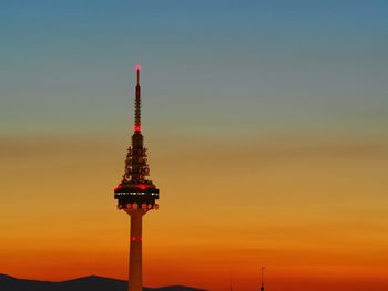 Communication tower against sky during sunset