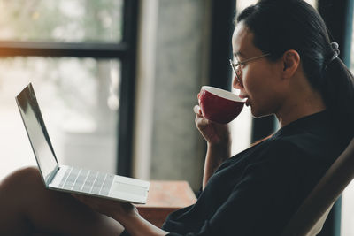 Midsection of woman holding coffee cup