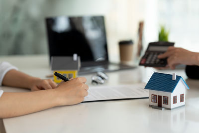 Cropped hands of woman using digital tablet on table