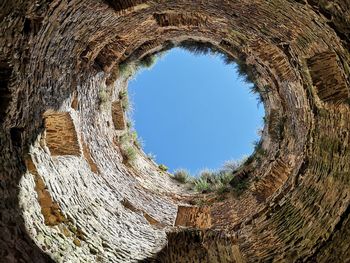 Directly below shot of stone wall against clear sky