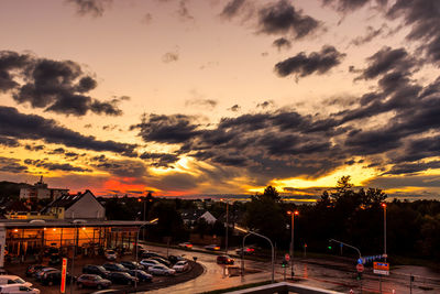 Parking lot against cloudy sky during sunset