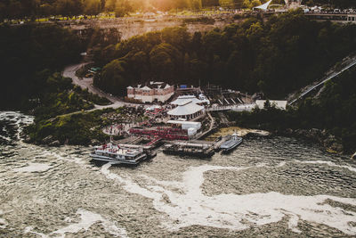 High angle view of ferry boats moored on river against trees